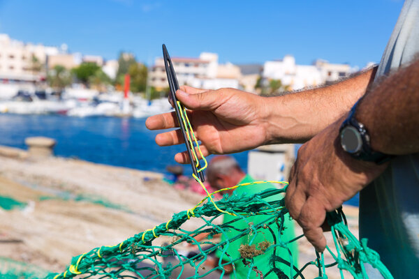 Majorca Cala Ratjada fisherman sewing fishing net