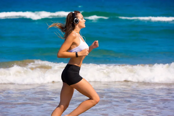 Brunette meisje uitgevoerd op het strand-hoofdtelefoon — Stockfoto