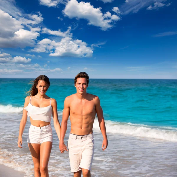 Casal jovem caminhando em uma praia tropical mediterrânea — Fotografia de Stock