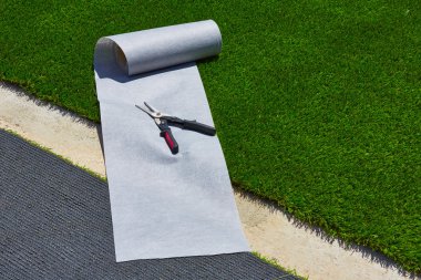 Artificial grass turf installation in garden with tools clipart
