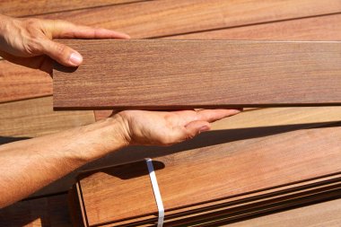Ipe deck installation carpenter hands holding wood clipart