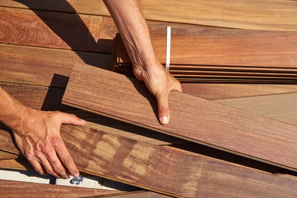 Ipe cubierta instalación carpintero manos sosteniendo madera —  Fotos de Stock