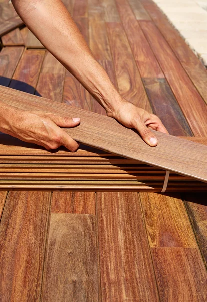 IPE κατάστρωμα εγκατάσταση ξυλουργός χέρια που κρατούν ξύλο — Φωτογραφία Αρχείου