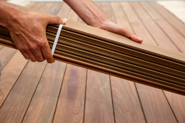 Ipe cubierta instalación carpintero manos sosteniendo madera —  Fotos de Stock