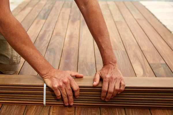 Ipe deck instalação carpinteiro mãos segurando madeira — Fotografia de Stock