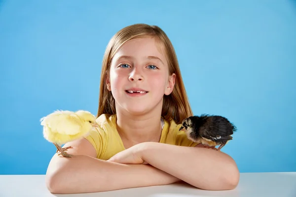 Menina criança com filhotes jogando no azul — Fotografia de Stock