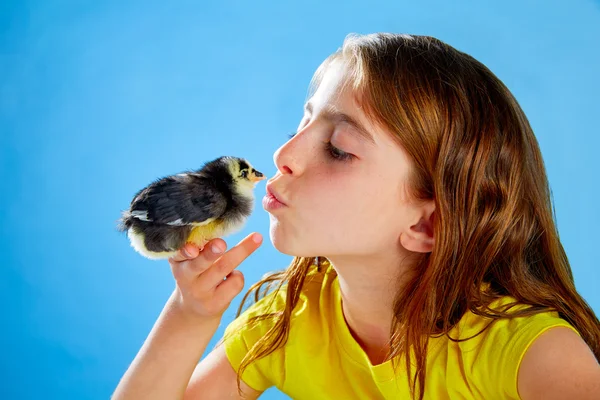 Mädchen mit Küken spielen auf blau — Stockfoto