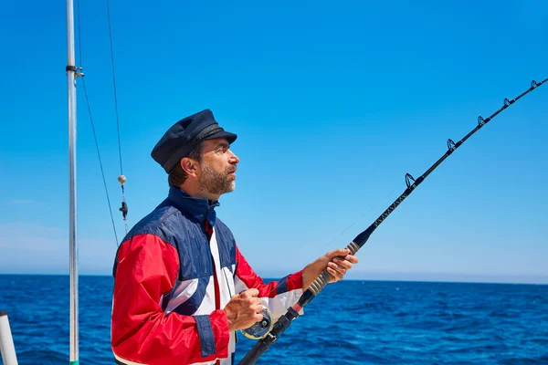 Barba marinero hombre caña de pescar curricán en agua salada —  Fotos de Stock