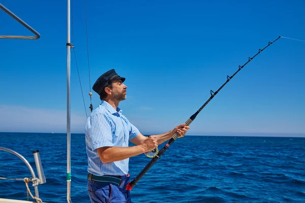 Skägg sailor man fiskespö trolling i saltvatten — Stockfoto