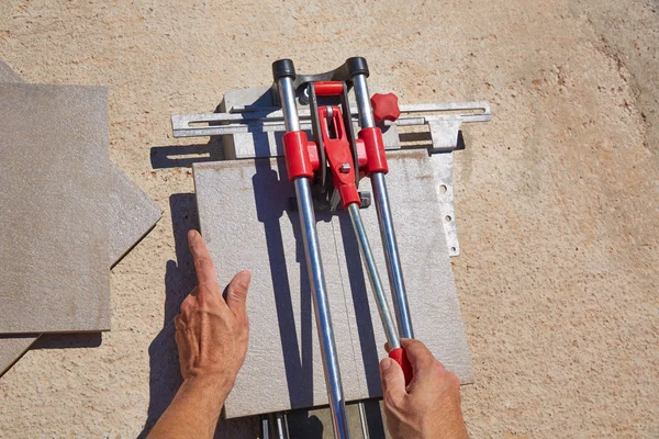 Fliesenschneidemaschine mit Maurer Hände schneiden — Stockfoto