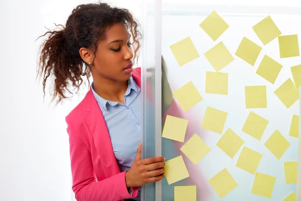 Afrikaanse etnische uitvoerend met stickers in office — Stockfoto