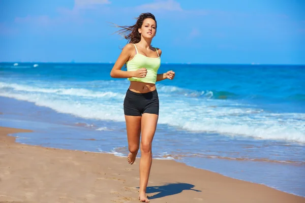 Bella ragazza bruna che corre in una spiaggia estiva — Foto Stock