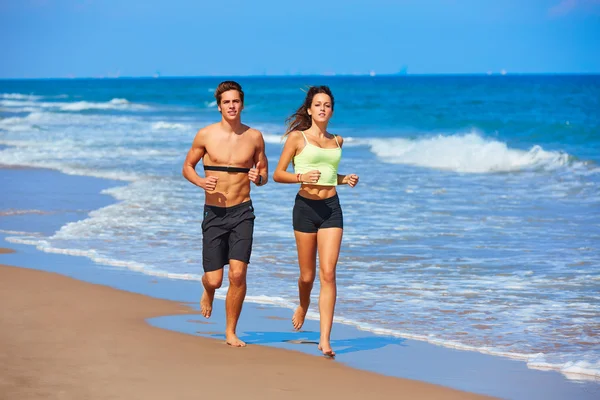 Casal de jovens correndo na praia no verão — Fotografia de Stock