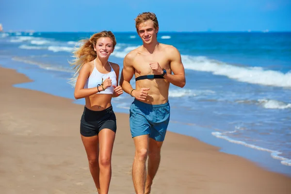 Loira jovem casal correndo em uma praia no verão — Fotografia de Stock