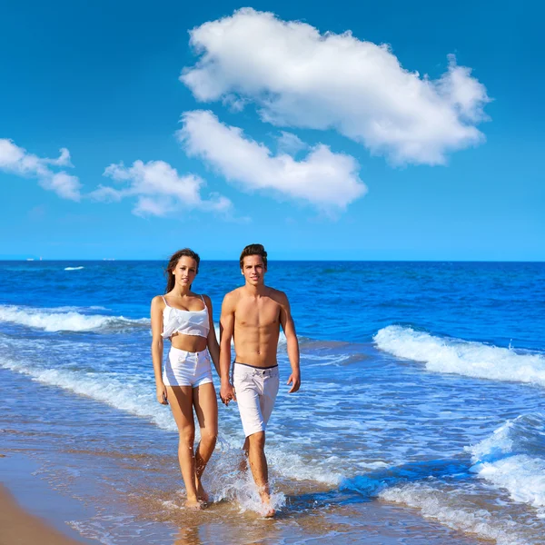 Plaj kıyısında yürüyen çift genç — Stok fotoğraf