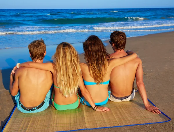 Vänner grupp par sitter i beach sand bakre — Stockfoto