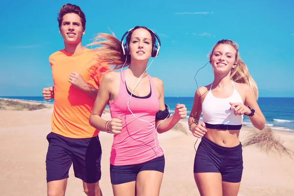 Amigos corriendo en la playa feliz en verano — Foto de Stock