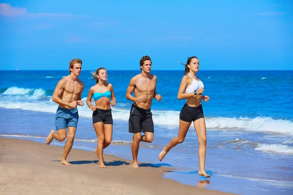 Gruppe junger Leute läuft am Strand — Stockfoto