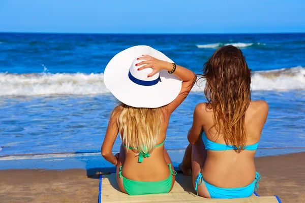 Дівчата на пляжі заднього виду сидять на пляжі — стокове фото