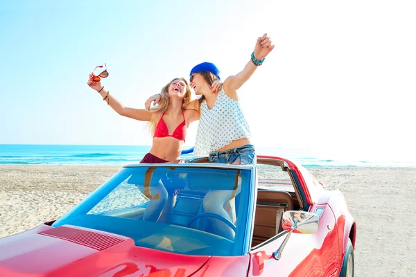 Beautiful party girls dancing in a car on the beach — Stock Photo, Image