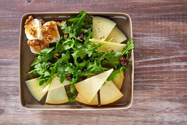 Ensalada de rúcula con miel de queso de cabra y frutos secos — Foto de Stock