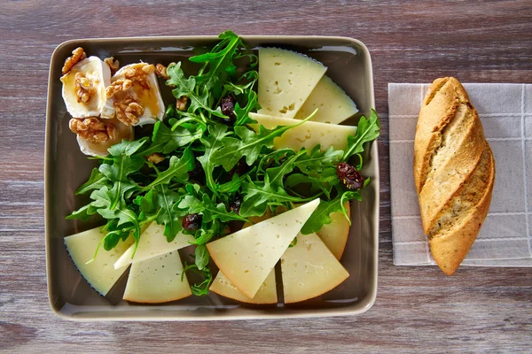 Ensalada de rúcula con miel de queso de cabra y frutos secos — Foto de Stock