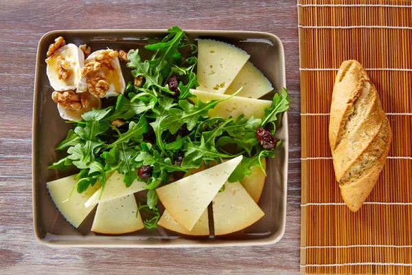 Ensalada de rúcula con miel de queso de cabra y frutos secos — Foto de Stock