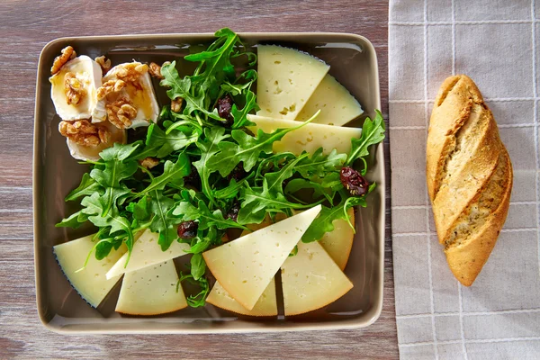 Ensalada de rúcula con miel de queso de cabra y frutos secos — Foto de Stock