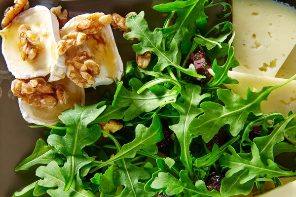 Ensalada de rúcula con miel de queso de cabra y frutos secos — Foto de Stock