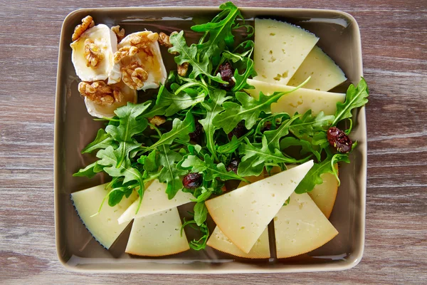 Ensalada de rúcula con miel de queso de cabra y frutos secos — Foto de Stock
