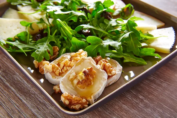 Ensalada de rúcula con miel de queso de cabra y frutos secos — Foto de Stock