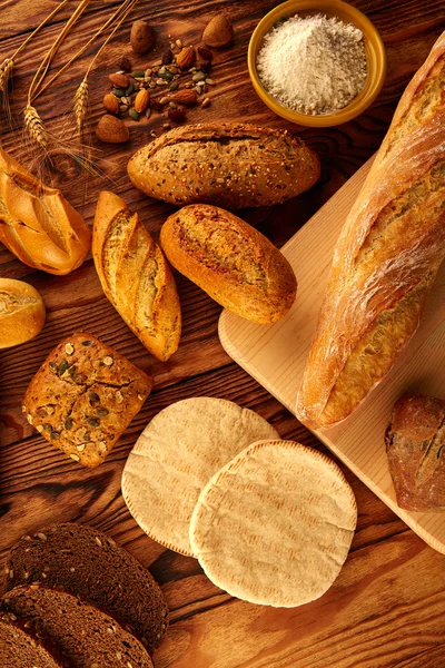 Ψωμί ποικίλη αναμειγνύεται σε χρυσή ηλικίας ξύλινος πίνακας — Φωτογραφία Αρχείου