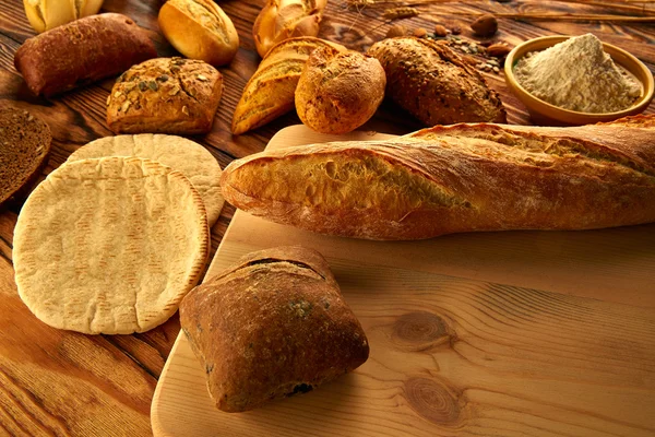Хліб різноманітна суміш на золотистому старіючому дерев'яному столі — стокове фото