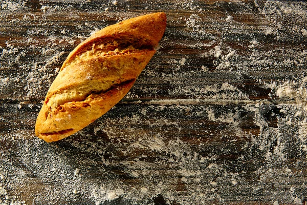 Pão de pão em uma madeira rústica e farinha de trigo — Fotografia de Stock