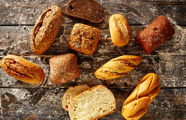 Pan de pan mezclado en una madera rústica y harina de trigo — Foto de Stock