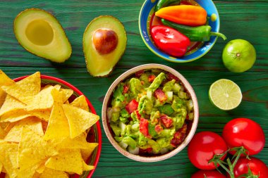 Guacamole with avocado tomatoes and nachos clipart