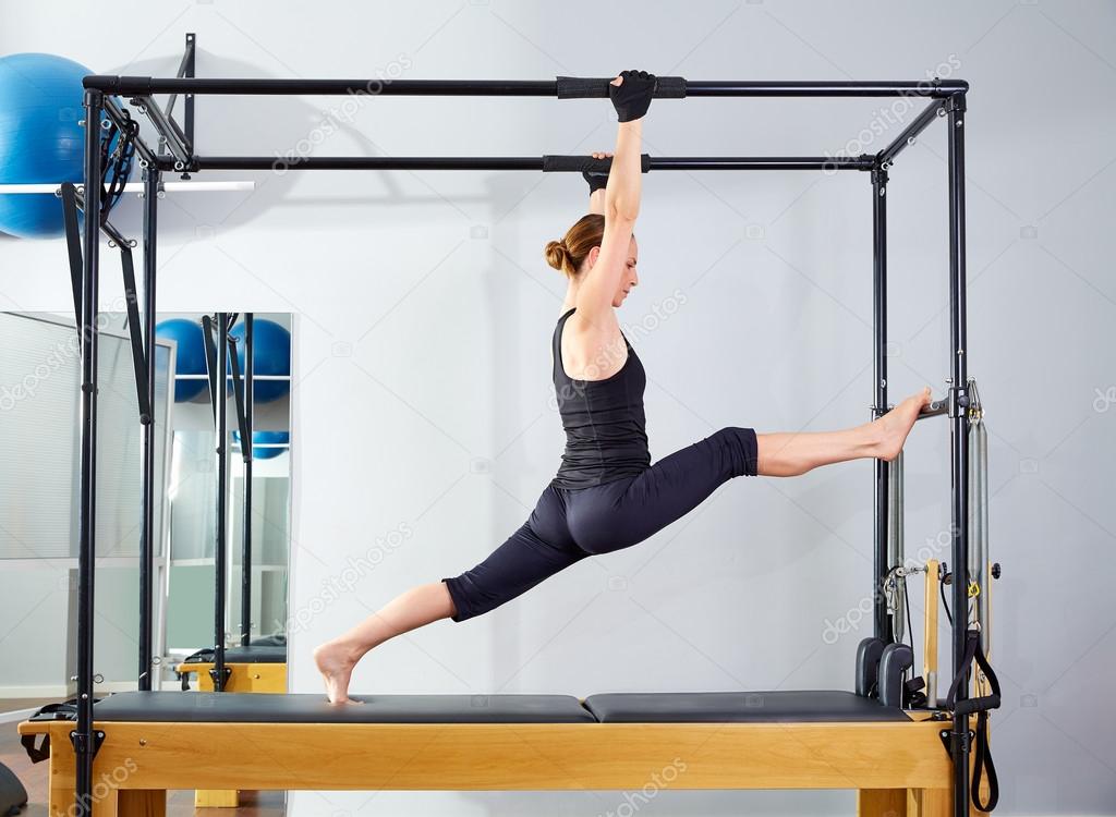Pilates woman in cadillac legs split reformer — Stock Photo