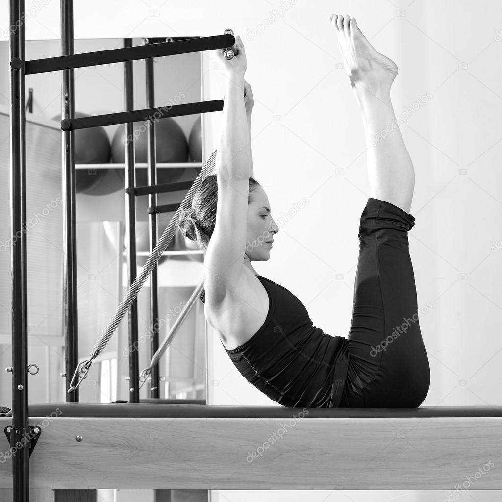 Pilates woman in reformer exercise at gym