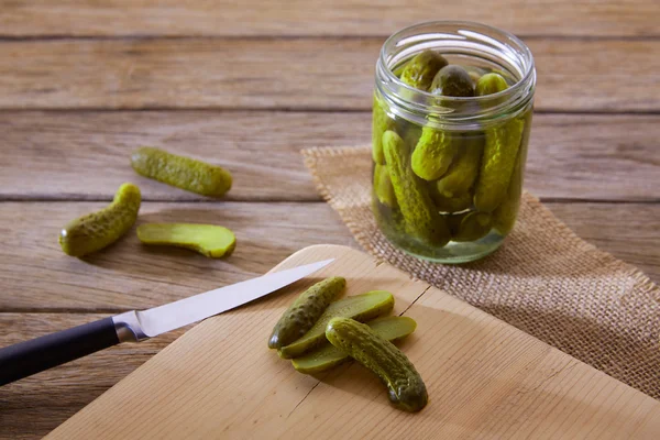 Gebotteld augurken komkommers in houten tafel — Stockfoto