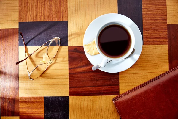 Taza de café con vasos y carpeta de cuero en la mesa retro —  Fotos de Stock