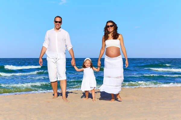 Família feliz na areia da praia caminhando — Fotografia de Stock