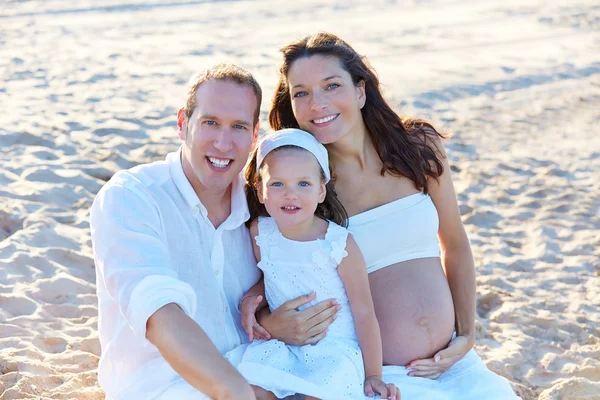Семья с беременной матерью на пляже песка — стоковое фото