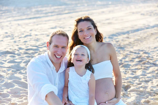 Family with pregnant mother on the beach sand — Stock Photo, Image