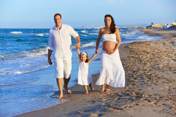 Familia feliz en la arena de la playa caminando — Foto de Stock