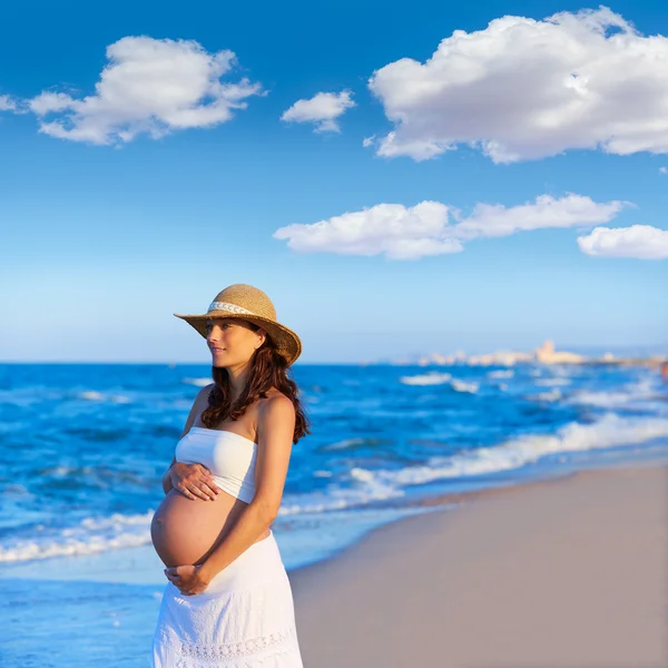 Mulher grávida bonita na praia com chapéu — Fotografia de Stock