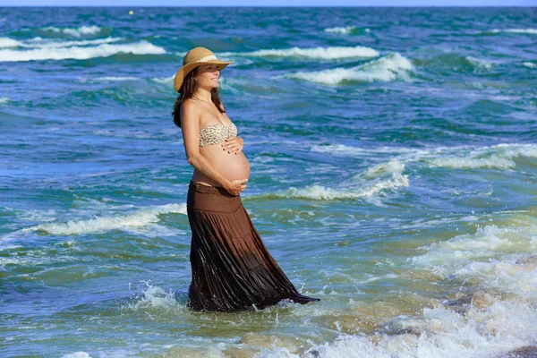 Dalgalar ile sahilde hamile kadın — Stok fotoğraf