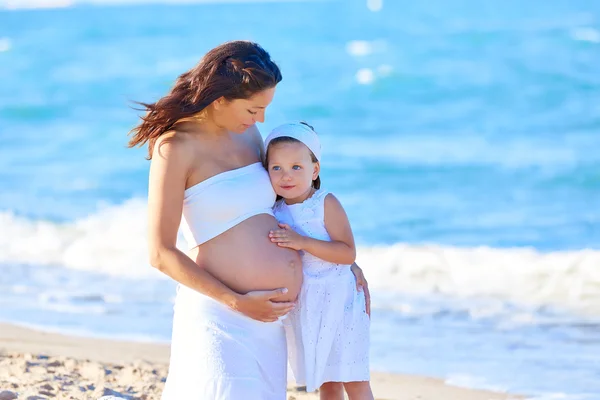 Incinta madre e figlia sulla spiaggia — Foto Stock