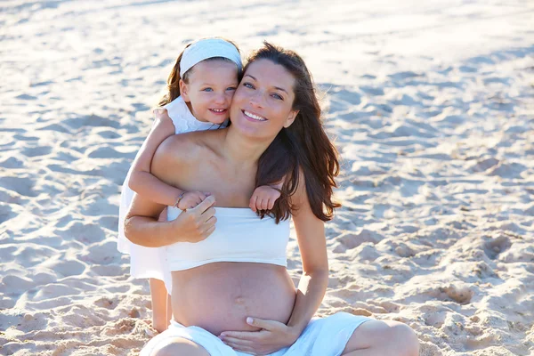 Gravid mor och dotter på stranden — Stockfoto