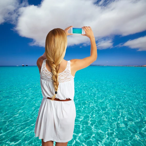 Blond fläta turist flicka smartphone foto beach — Stockfoto