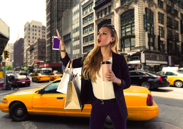 Loira compras turista menina chamando um táxi amarelo NYC — Fotografia de Stock